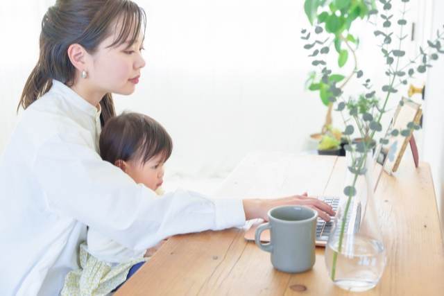 仕事をする女性と子供